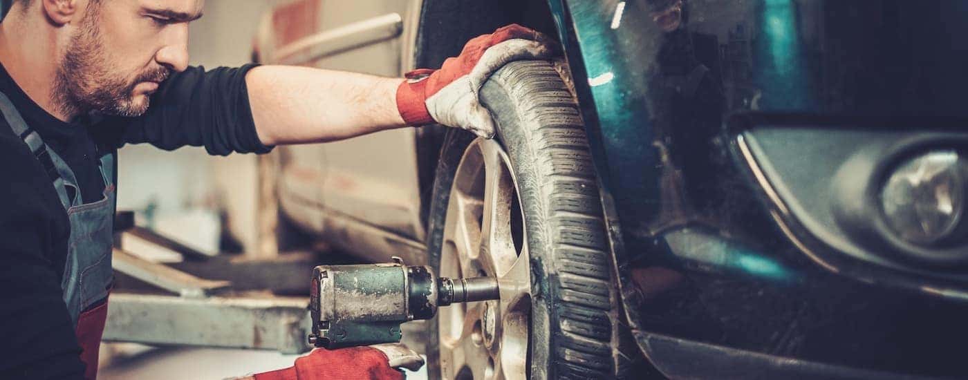 A close up shows a mechanic using an impact to install a tire after Joliet tire service.