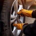 A gloved mechanic adjusts a tire during a Joliet tire service.