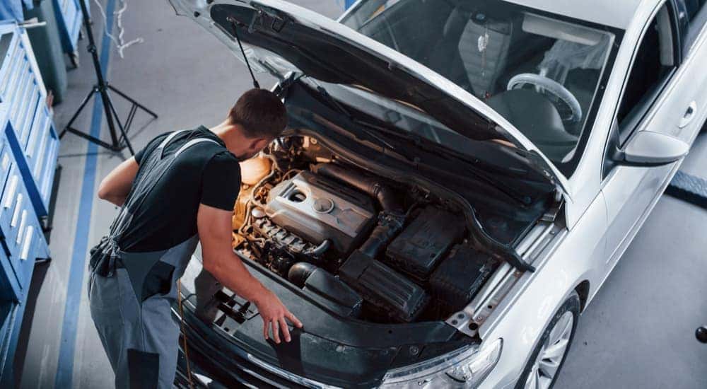 A mechanic is shown looking at a car engine during a Chicagoland Nissan service.