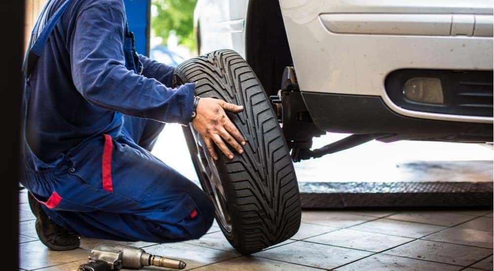 A mechanic is shown rotating a tire during a Chicagoland Nissan service.