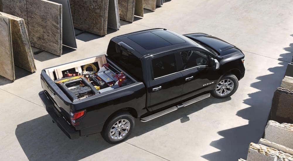 A black 2021 Nissan Titan is shown from a high angle with tools and supplies in the bed.