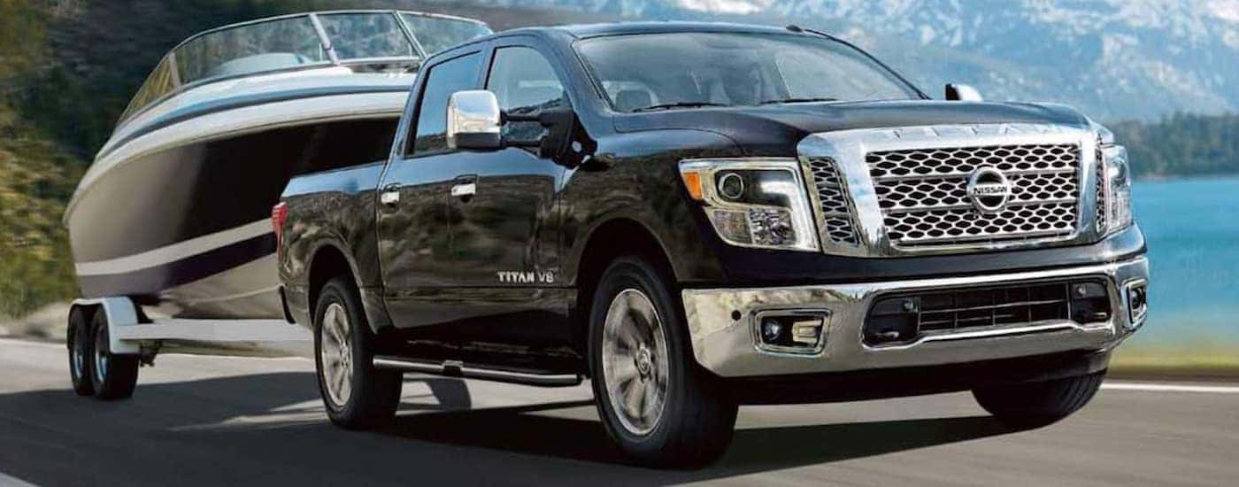 A black 2019 Nissan Titan is shown towing a boat.