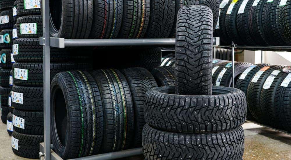 A stack of studded snow tires are shown in a tire shop.