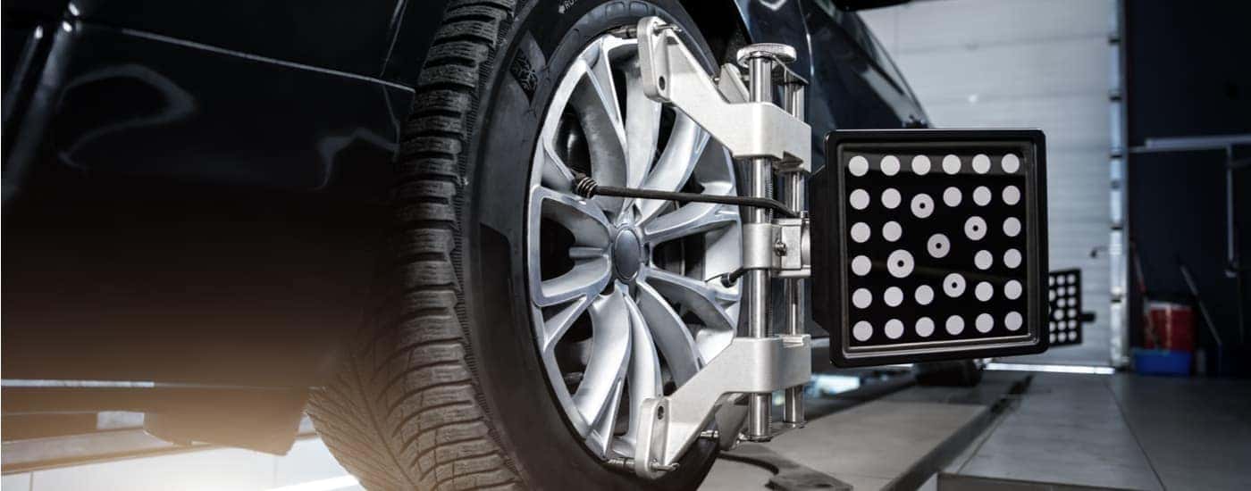 A close up of a car tire during an auto alignment near you is shown.