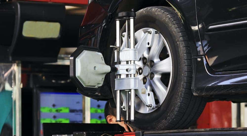 A black car is shown in close up during an auto alignment.