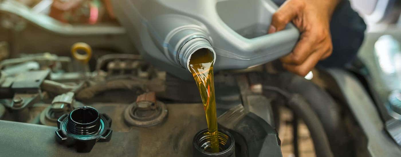 A mechanic is shown preforming an oil change.