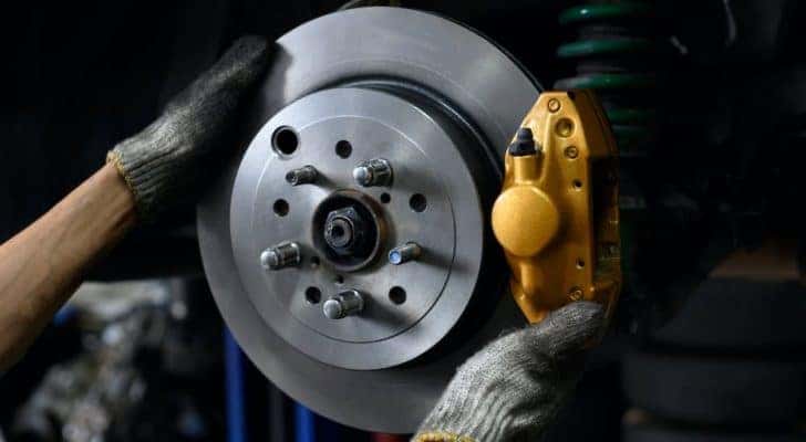A mechanic is shown replacing working on a brake during at a brake service near you.