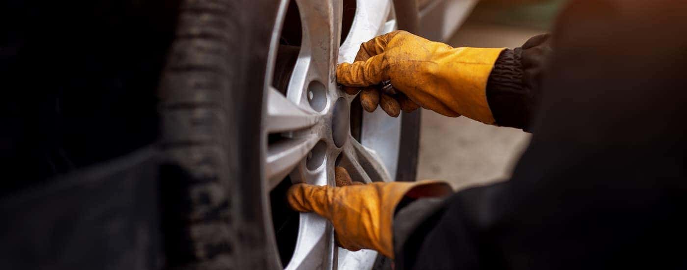 A mechanic is shown changing a tire.