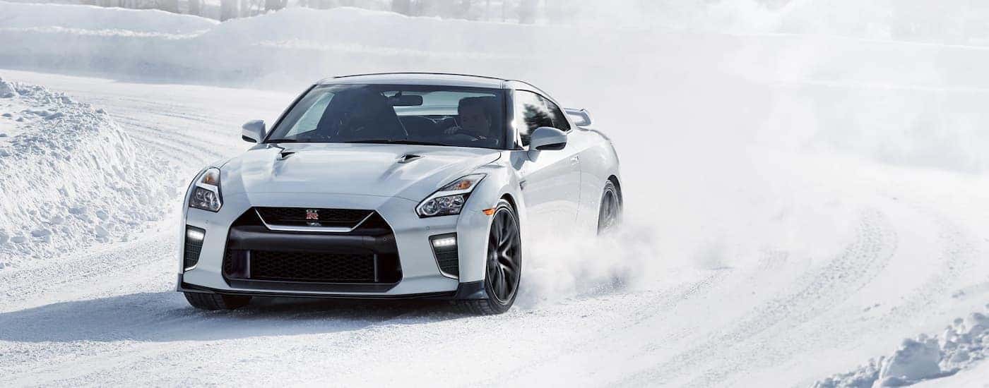 A white 2019 Nissan GT-R is shown driving on a snow covered trail.