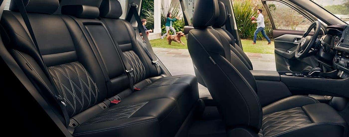 The black leather interior is shown in a 2021 Nisan Rogue.