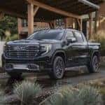 A black 2022 GMC Sierra 1500 Denali Ultimate is shown parked in a driveway after leaving a GMC Sierra 1500 dealer.