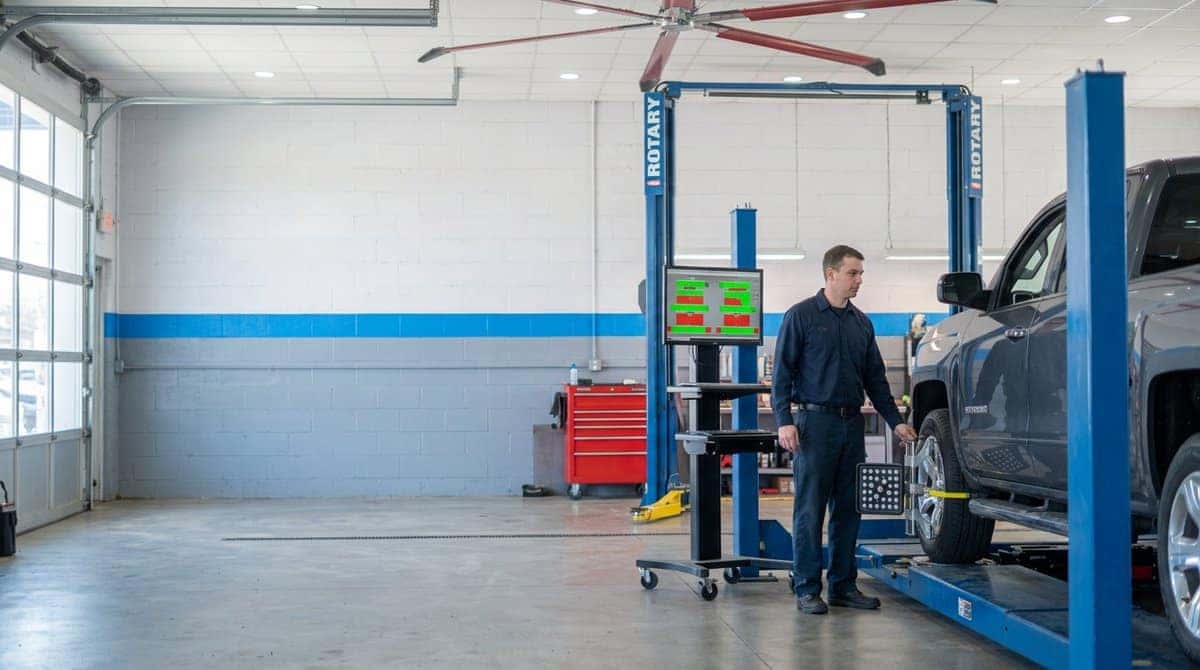 A Chevrolet Silverado on the four-wheel alignment rack at Yoder Chevrolet with the alignment readings on screen