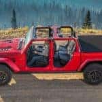 A red 2020 Jeep Gladiator Rubicon is shown from above, driving on a dirt trail without a roof or doors. Find one at a Jeep dealer near me.
