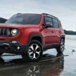 A popular Jeep model, a red 2020 Jeep Renegade is parked on a beachl.