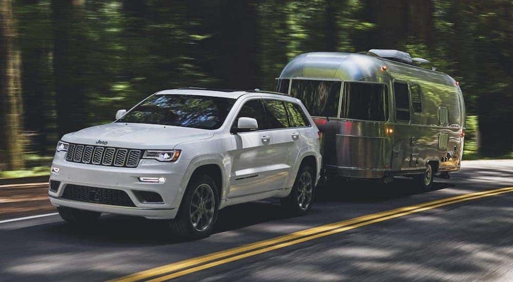 A white 2020 Jeep Grand Cherokee is towing an Airstream trailer on a road outside Florence, KY.