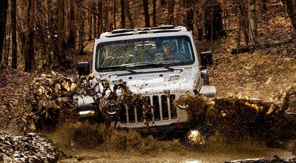 A white 2021 Jeep Wrangler is off-roading in mud near Florence, KY.