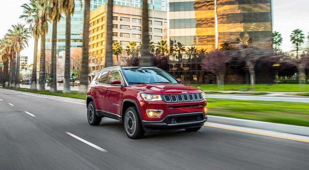 A red 2020 Jeep Compass is driving through the city.