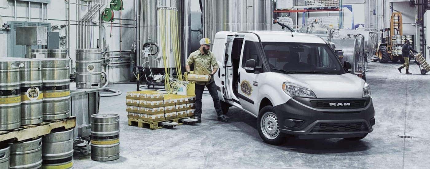 Beer is being loaded into a 2021 Ram Promaster City in a distillery.