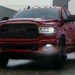 A red 2021 Ram 3500 is parked in front of shipping crates after leaving a Cincinnati Ram Diesel Truck Dealer.
