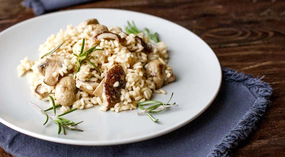 A plate with Mushroom Risotto is on a blue napkin.
