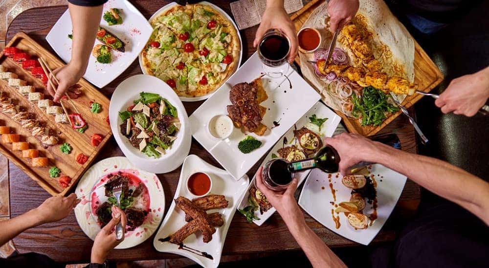 A table with food and hands holding drinks is shown from above in Burlington, KY.