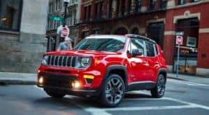 A red 2021 Jeep Renegade is driving around a city street after leaving a Cincinnati Jeep dealer.