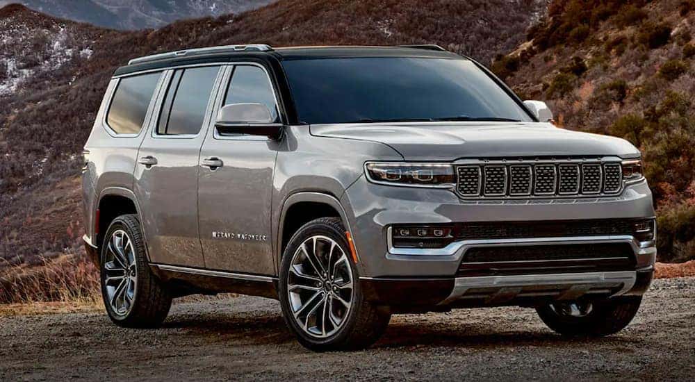 A silver 2022 Grand Wagoneer is parked in front of mountains.
