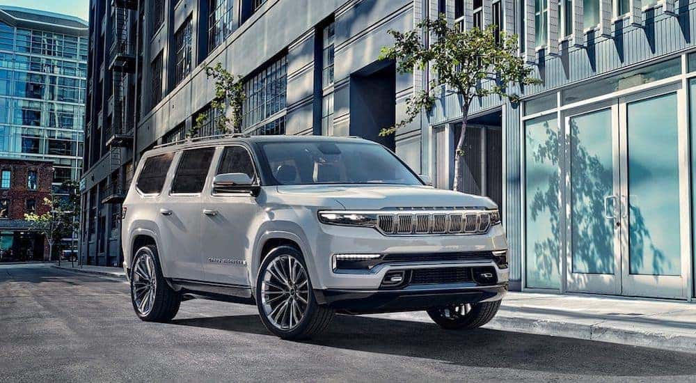 A white 2022 Grand Wagoneer is shown parked in the city after leaving a Covington Jeep dealership.