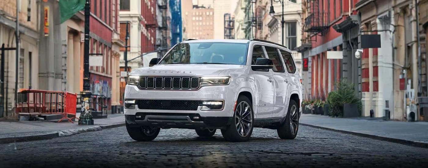 A white 2024 Jeep Wagoneer is shown parked on a city street.