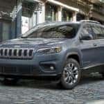 A grey 2021 Jeep Cherokee is shown from an angle parked on a cobblestone road after leaving a Ohio Jeep dealer.