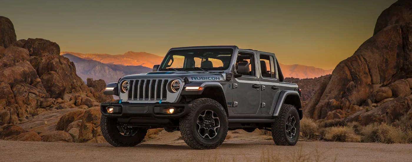 A grey 2021 Jeep Wrangler 4xe is shown with no roof at sunset.