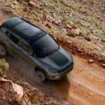 A grey 2019 Jeep Compass is shown from above driving on a dirt road after leaving a pre-owned Jeep dealer.