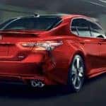 A red 2018 Toyota Camry XSE is shown from the rear driving through a tunnel.