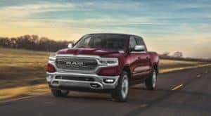 A maroon 2020 Ram 1500 is driving down a highway.