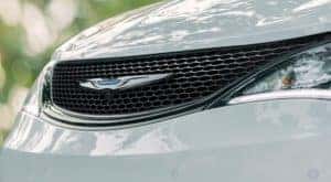 A close up shows the grille of a white 2020 used Chrysler Pacifica.
