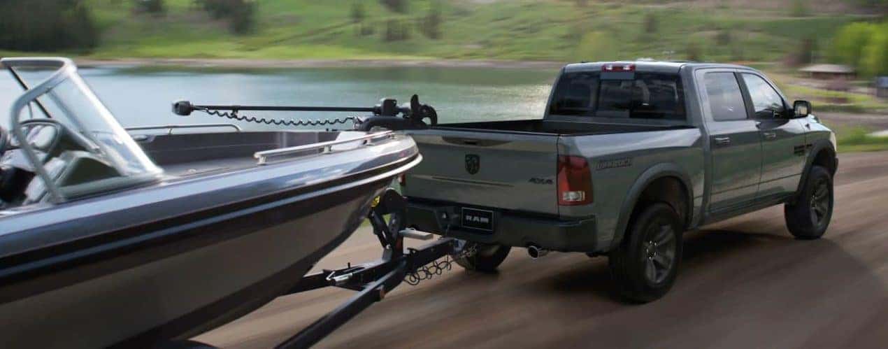 A green 2022 Ram 1500 is shown towing a boat.