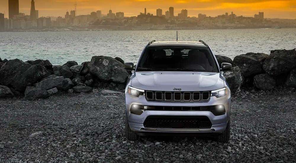 A silver 2022 Jeep Compass is shown parked on a lake shore.
