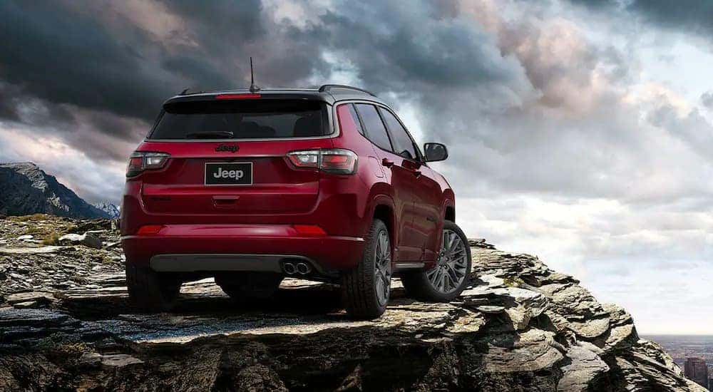 A red 2022 Jeep Compass is shown in the mountains overlooking a city after visiting a Cincinnati Jeep dealer.
