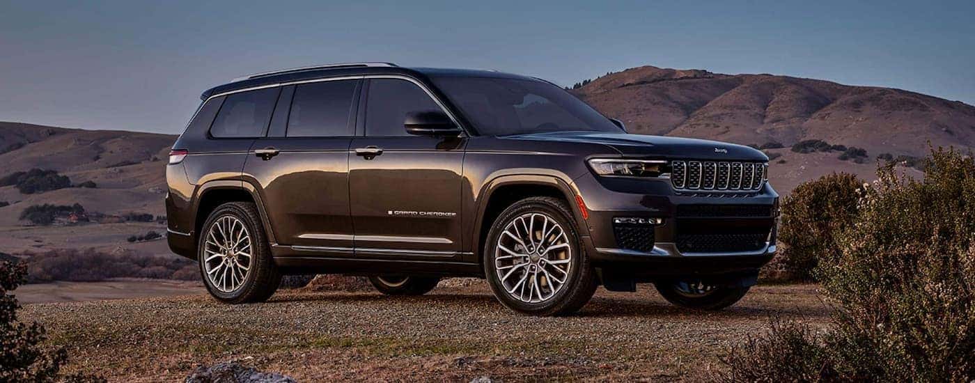 A black 2023 Jeep Grand Cherokee is shown parked in an open area.