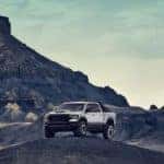 A white 2021 Ram 1500 TRX is shown parked on a hill in a remote desert area.