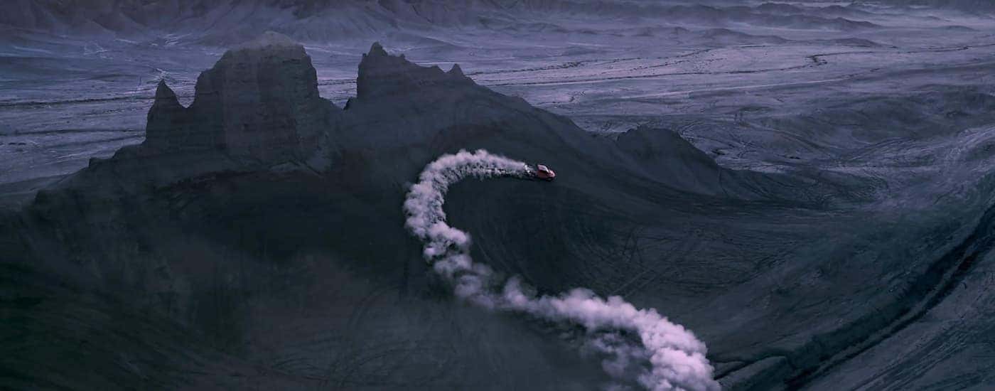 A red 2021 Ram 1500 TRX is shown off-roading in a desert.