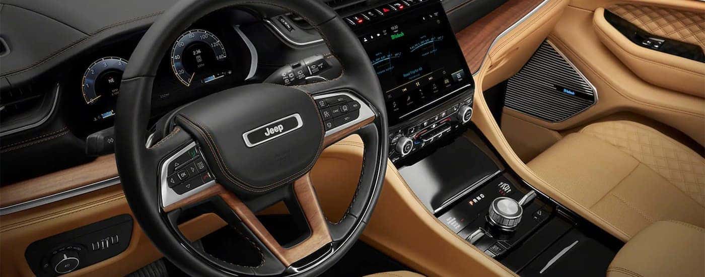 The front black and brown interior is shown in a 2021 Jeep Grand Cherokee L.