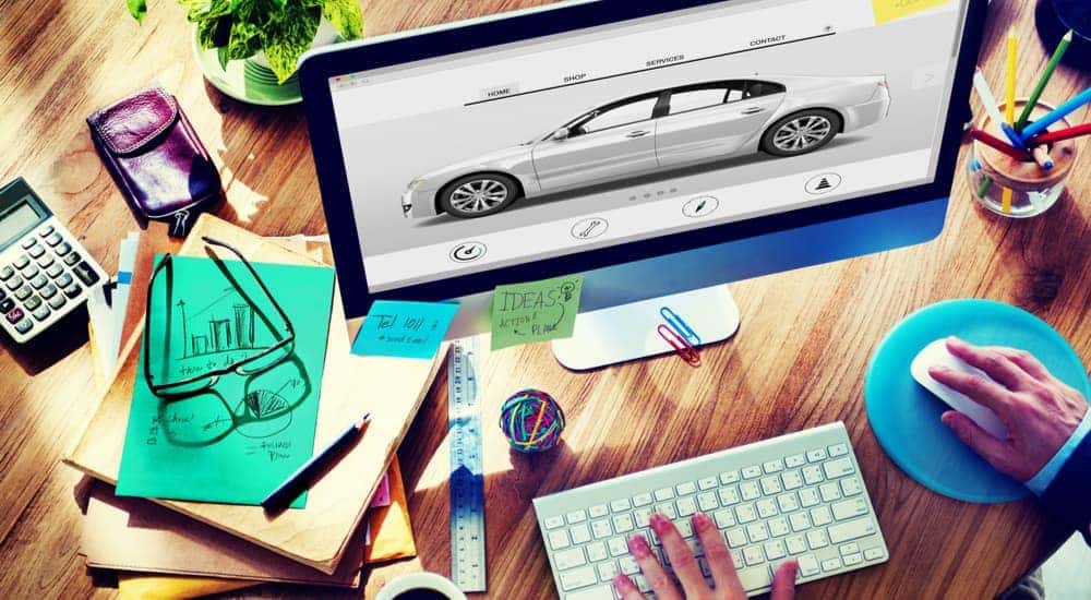 A desktop computer screen shows a person researching 'how to sell your car.'
