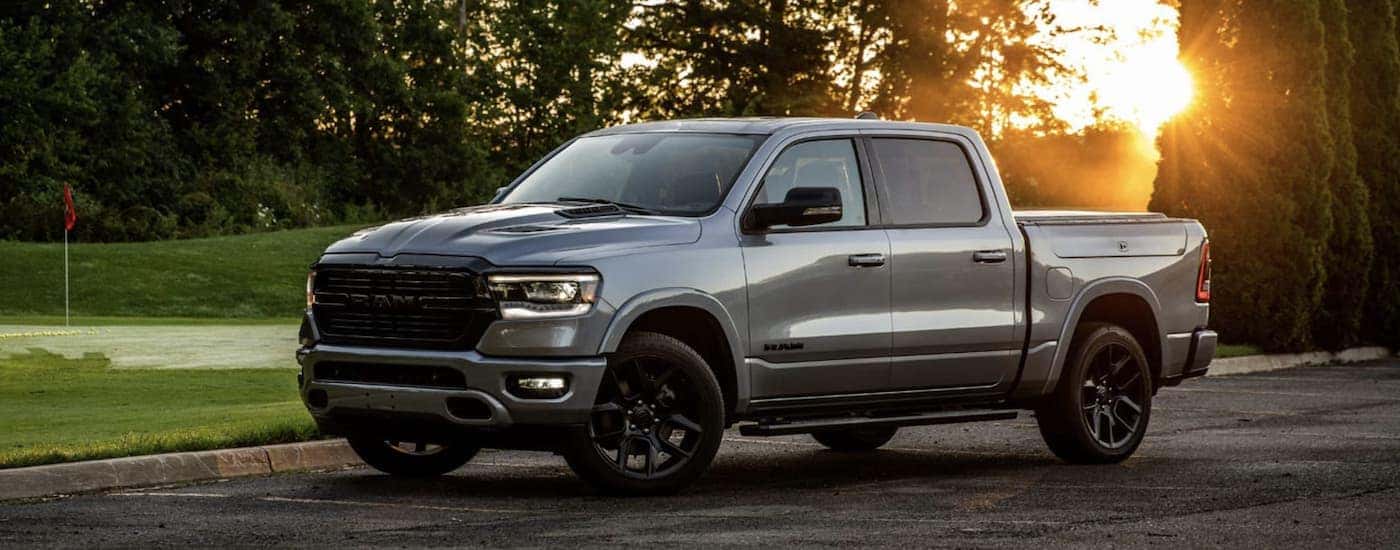 A grey 2022 Ram 1500 is shown from the side parked next to a golf course.