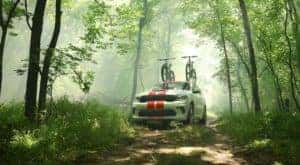 A white 2020 Dodge Durango is shown in the woods with bikes on the roof.