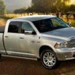 A popular Certified pre-owned Ram, a silver 2017 Ram 1500 is shown from the side parted at a vineyard.