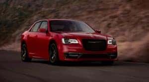 A red 2020 Chrysler 300 is shown driving on a road after leaving a Certified Pre-Owned Chrysler dealer.