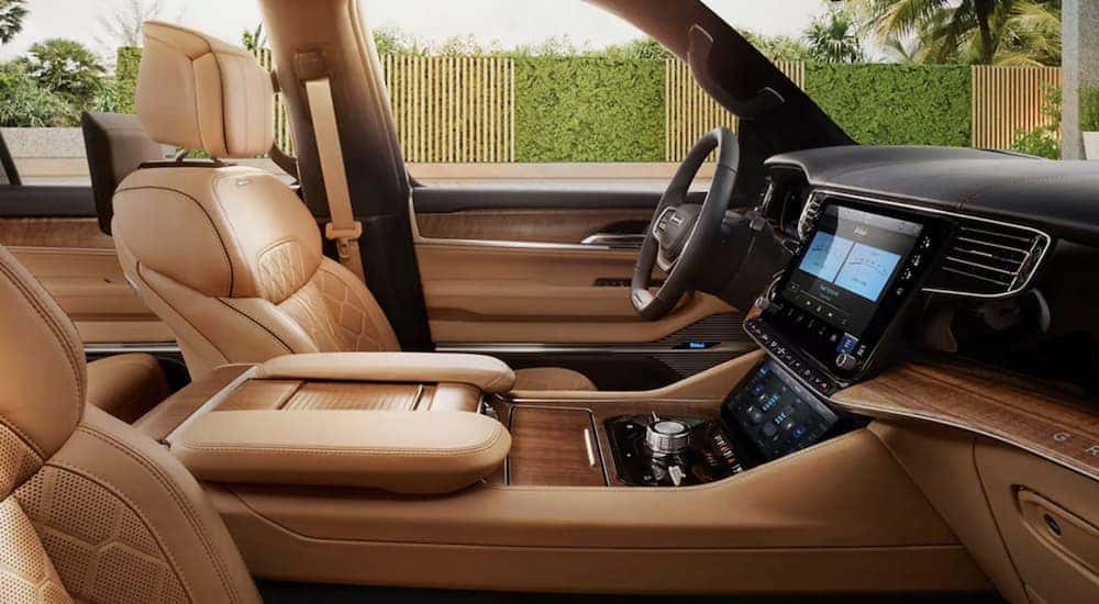 The tan interior of a 2022 Grand Wagoneer shows the front seats and steering wheel.