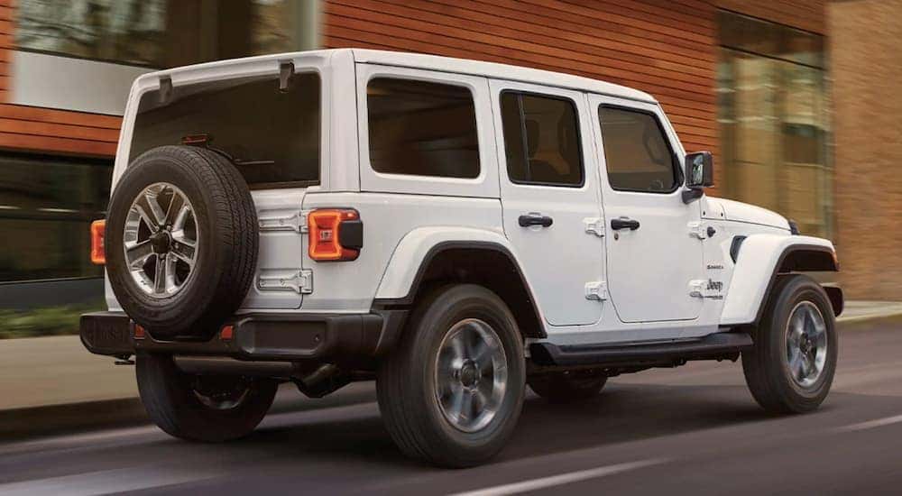 A white 2022 Jeep Wrangler is shown from the rear driving on an open road after leaving a Cincinnati Jeep Wrangler dealer.