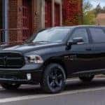 A black 2021 Ram 1500 Classic is shown parked on the side of a city street.